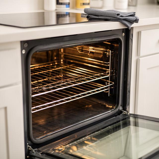 Open oven with spotless racks and glass door after a detailed kitchen add-on service