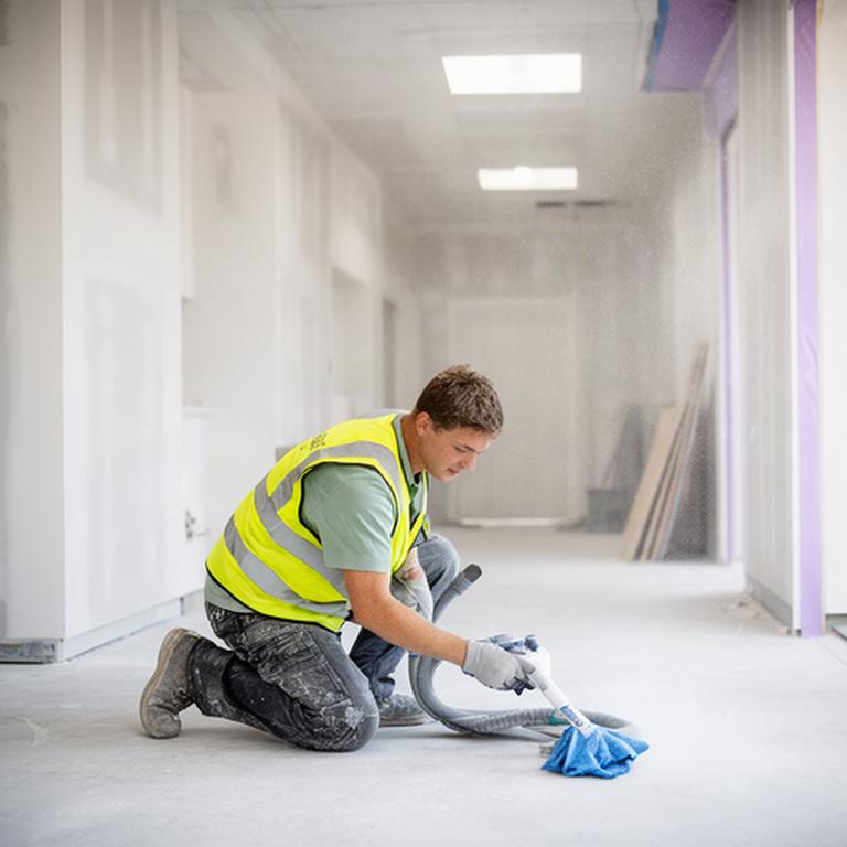 Post-construction cleaner removing fine dust from a newly finished commercial space